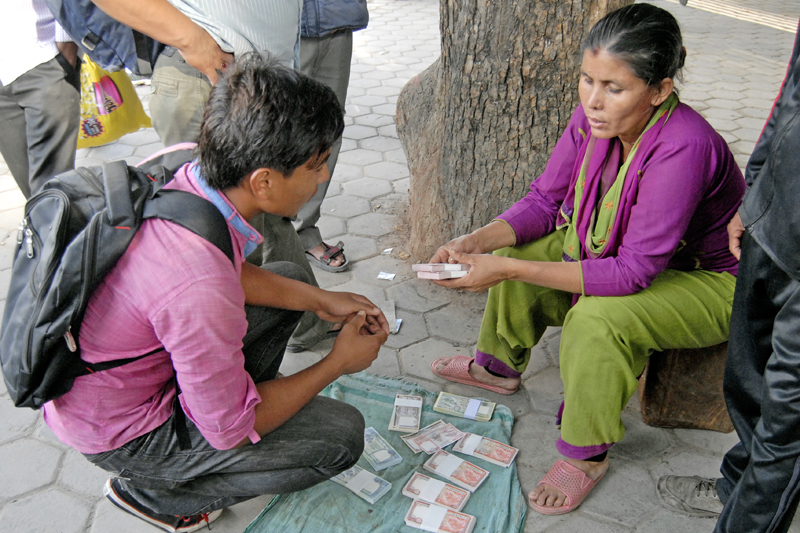 A woman selling fresh banknotes in Ratnapark, Kathmandu, on Thursday, October 15, 2015. Photo: THT