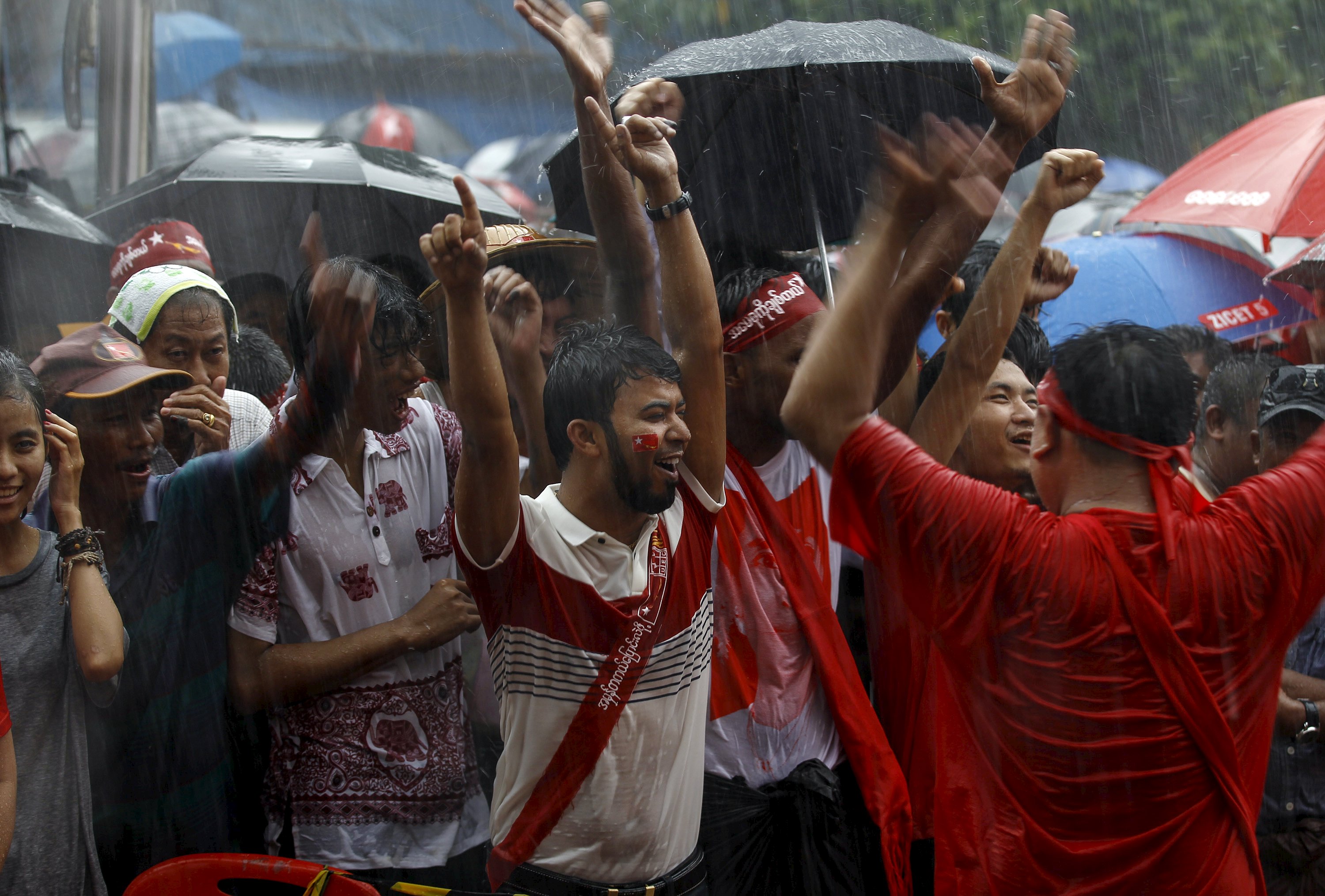 Supporters celebrate as they wait for official results of the elections from the Union Election Commission during heavy rain fall in front of the National League for Democracy Party (NLD) head office at Yangon, November 9, 2015. Photo: AFP