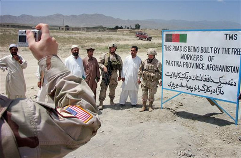US military operational commander in Afghanistan, Maj. Gen. Jason Kamiya, right, poses with Afghan workers and a US soldier for a photo in a US military-funded road through Urgun town in Paktika province, eastern Afghanistan on July 23, 2005. Photo: AP