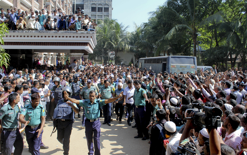 Bangladeshi people gather outside a court as police escort the accused youth in the killing of Bangladeshi boy Samiul Islam Rajon, before a verdict in Sylhet, Bangladesh, Sunday, Nov. 8, 2015. Rajon, 13, died in July after he was brutally beaten. A 28-minute video of Rajon screaming for help as he was being beaten was posted online and went viral, shocking a nation long inured to violence against children. The main suspect in Rajon's death, Kamrul Islam, and three others guilty of fatally torturing the boy were sentenced to death.Photo: AP