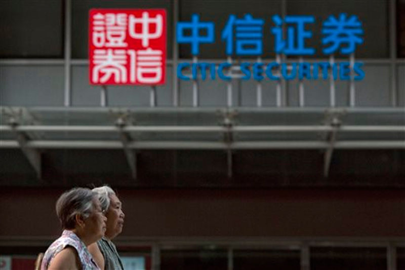Elderly Chinese women walk near the logo for Citic Securities in Beijing on Wednesday, August 26, 2015. Photo: AP