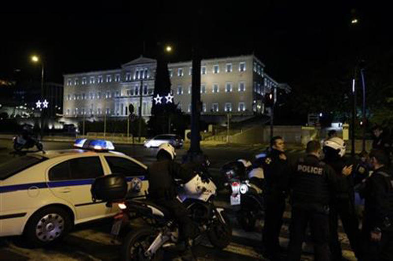 Police block an avenue near the Federation of Greek Enterprises as the Greek Parliament is seen in the background in central Athens early Tuesday, Nov. 24, 2015. Photo: AP