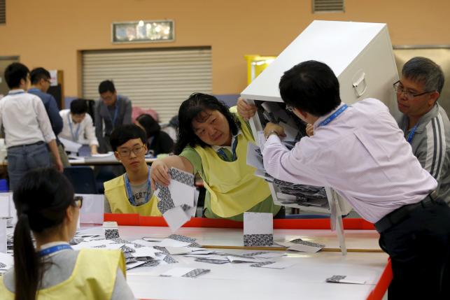 Electoral officers empty a ballot box at a polling station in Hong Kong, China November 22, 2015. REUTERS/Tyrone Siu