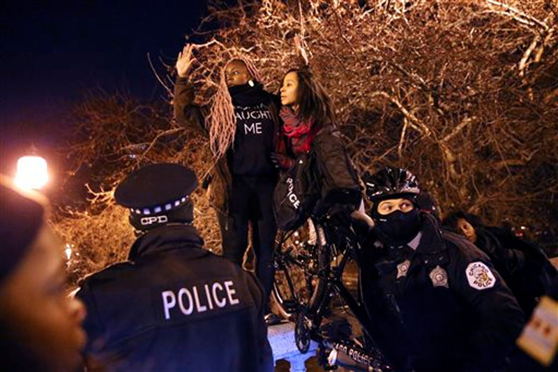 Police officers block protesters in Chicago, on Tuesday, November 24, 2015. White Officer Jason Van Dyke who shot Laquan McDonald 16 times last year was charged with first-degree murder Tuesday, hours before the city released a video of the killing. Photo: AP