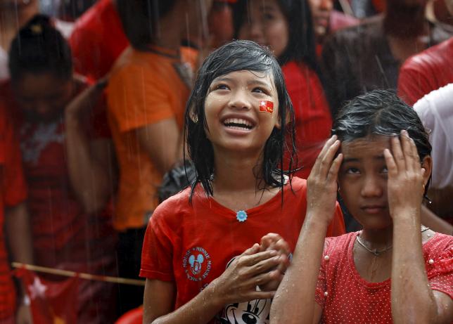 Supporters celebrate as they wait for official results from the Union Election Commission during heavy rain fall in front of the National League for Democracy Party (NLD) head office at Yangon, November 9, 2015. REUTERS/Soe Zeya Tun