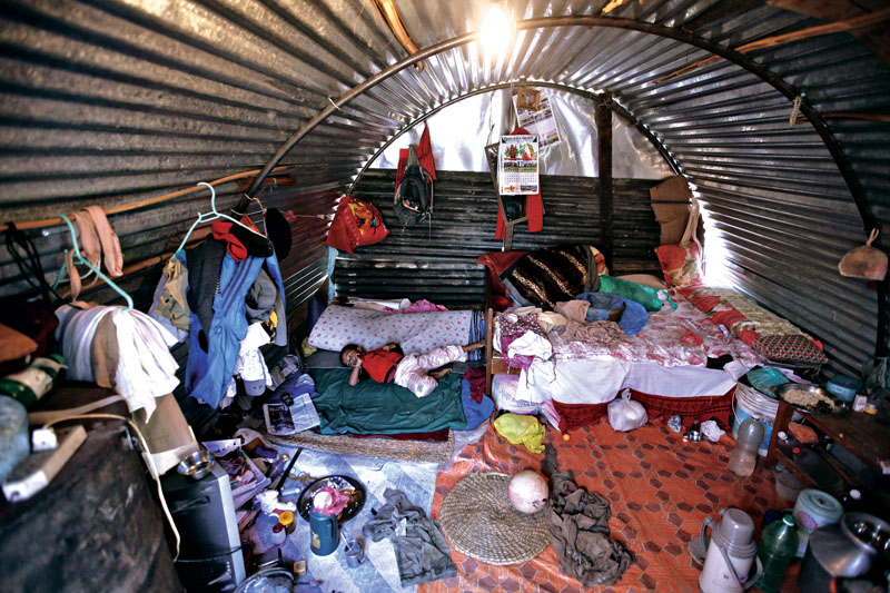 In this Oct. 20, 2015 photo, a Nepalese child victim of the April 25 earthquake lies inside a temporary shelter in Bhaktapur, Nepal. Aid groups are warning of a crisis unfolding in Nepal as winter approaches, especially for the many of the estimated 400,000 Nepalis who live at elevations of 1,500 meters (4,920 feet) or higher. Some are still living in temporary shelters in camps across the country, though there is no official number. Their tents and huts built with tin sheets protected them from the monsoon rain but will be little match for the snow and below-freezing temperatures expected in mountain villages by the end of November. (AP Photo/Niranjan Shrestha)