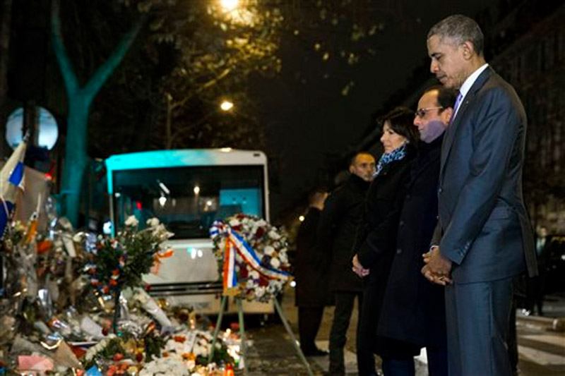 President Barack Obama (right), French President Francois Hollande (second from right) and Paris Mayor Anne Hidalgo pause for a moment of silence at the Bataclan, site of one of the Paris terrorists attacks, after Obama arrived in town for the COP21 climate change conference on Monday, November 30, 2015, in Paris. Photo: AP