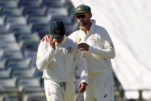 Australia's Usman Khawaja (L) is comforted by team mate Nathan Lyon after suffering an injury during the second day of the second cricket test match against New Zealand at the WACA ground in Perth, Western Australia, November 14, 2015. REUTERS/David Gray