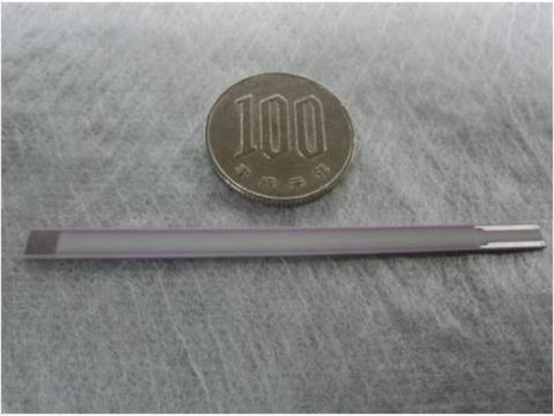 World's first platinum-free soot-sensing element (length: 67mm; width: 4mm; thickness: 1mm) for diesel engines developed by Kyocera and a Japanese 100-yen coin. Photo: AP