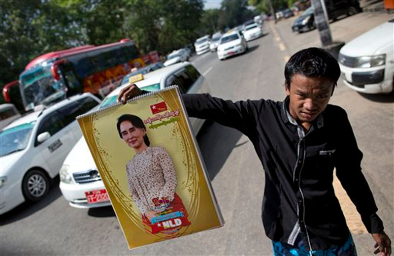 A street vender holds a calendar featuring Myanmar's opposition leader Aung San Suu Kyi in a Yangon street, Myanmar on Thursday, November 12, 2015. Photo: AP