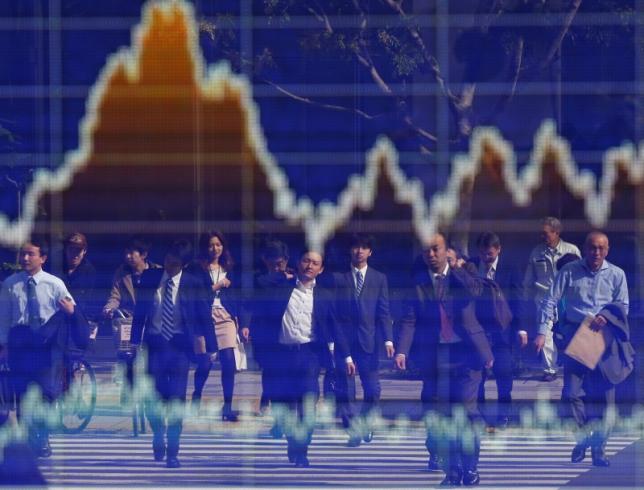 People are reflected on an electronic board displaying a graph showing the movement of Nikkei share average outside a brokerage in Tokyo November 7, 2012.   REUTERS/Toru Hanai