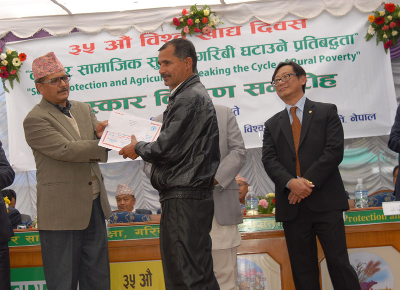 Minister for Agricultural Development Haribol Gajurel (left) awards a farmer, at a function organised in Kathmandu, on Tuesday, November 3, 2015. Photo: PACT