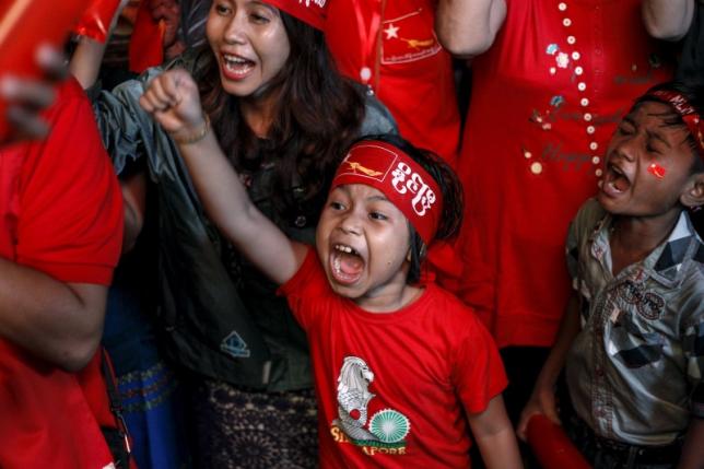 Supporters celebrate as they watch official results from the Union Election Commission on an LED screen in front of the National League for Democracy Party (NLD) head office in Yangon, November 9, 2015. REUTERS/Soe Zeya Tun