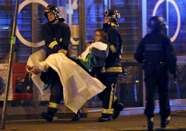 French fire brigade members aid an injured individual near the Bataclan concert hall following fatal shootings in Paris, France, November 13, 2015. REUTERS/Christian Hartmann