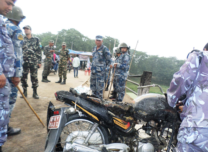 Police personnel inspect the incident site, where a bike was torched, at the Indo-Nepal border point, in Rautahat, on Saturday, November 28, 2015. Photo: Prabhat Kumar Jha