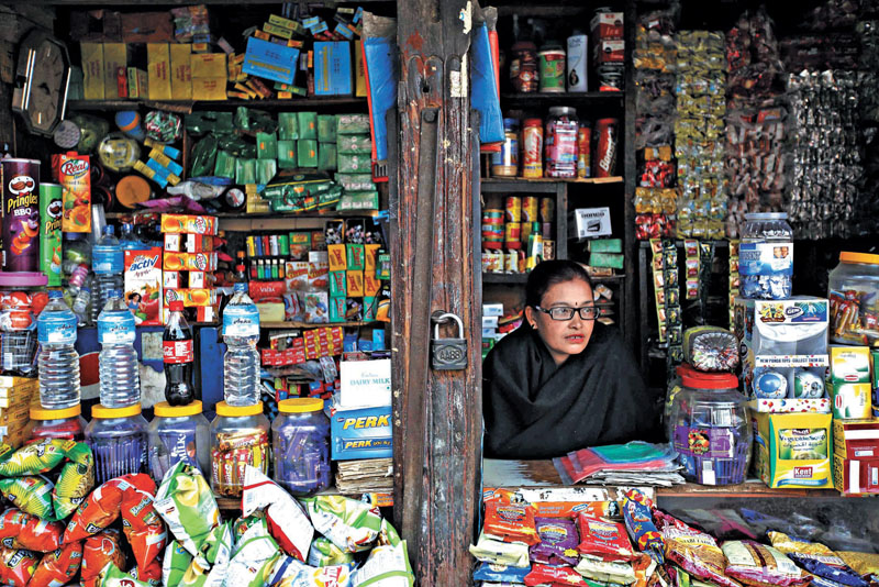 A woman waits for customer as she sits inside her shop along the street in Kathmandu January 24, 2014. REUTERS/Navesh Chitrakar (NEPAL - Tags: SOCIETY)