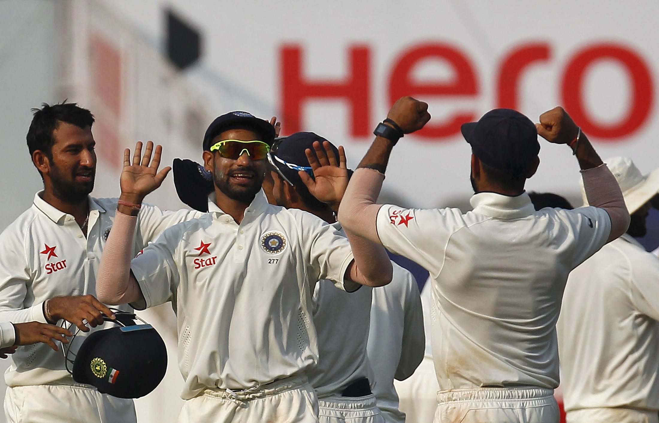 India's Cheteshwar Pujara (L), Shikhar Dhawan (C) and captain Virat Kohli celebrate after their win over South Africa on the third day of their third test cricket match in Nagpur, India, November 27, 2015. Photo: Reuters