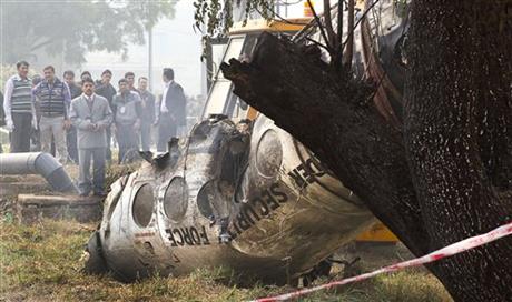 Indian investigators look at the remains of a small Indian paramilitary plane that crashed outside the airport in New Delhi, India, Tuesday, Dec. 22, 2015. Photo: AP