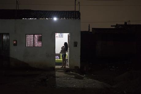 In this Dec. 22, 2015 photo, Angelica Pereira holds her daughter Luiza as she waits for her husband at their house in Santa Cruz do Capibaribe, Pernambuco state, Brazil. Photo: AP
