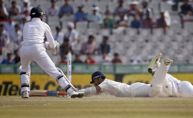 India's Ajinkya Rahane (R) dives successfully to make the crease as South Africa's wicketkeeper Dane Vilas watches during the third day of their first cricket test match, in Mohali, India, November 7, 2015. REUTERS/Adnan Abidi
