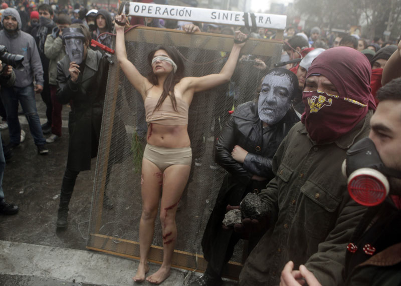 FILE- A group of actors perform a tortured session during a protest against the premiere of a documentary about the late Gen. Augusto Pinochet in Santiago, Chile on June 10, 2012.  Photo: AP