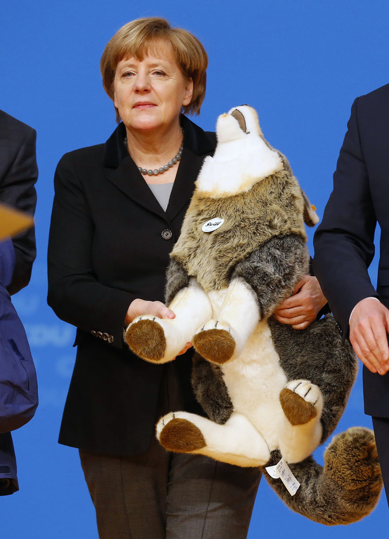 German Chancellor Angela Merkel holds a toy wolf she got as a present during a party convention of the Christian Democrats (CDU) in Karlsruhe, Germany on Monday, December 14, 2015. Photo: AP