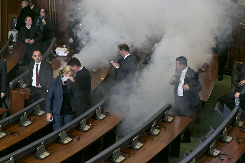 Lawmakers react as opposition lawmakers release tear gas canisters disrupting a parliamentary session in Kosovo capital Pristina on Monday December 14, 2015. Photo: AP