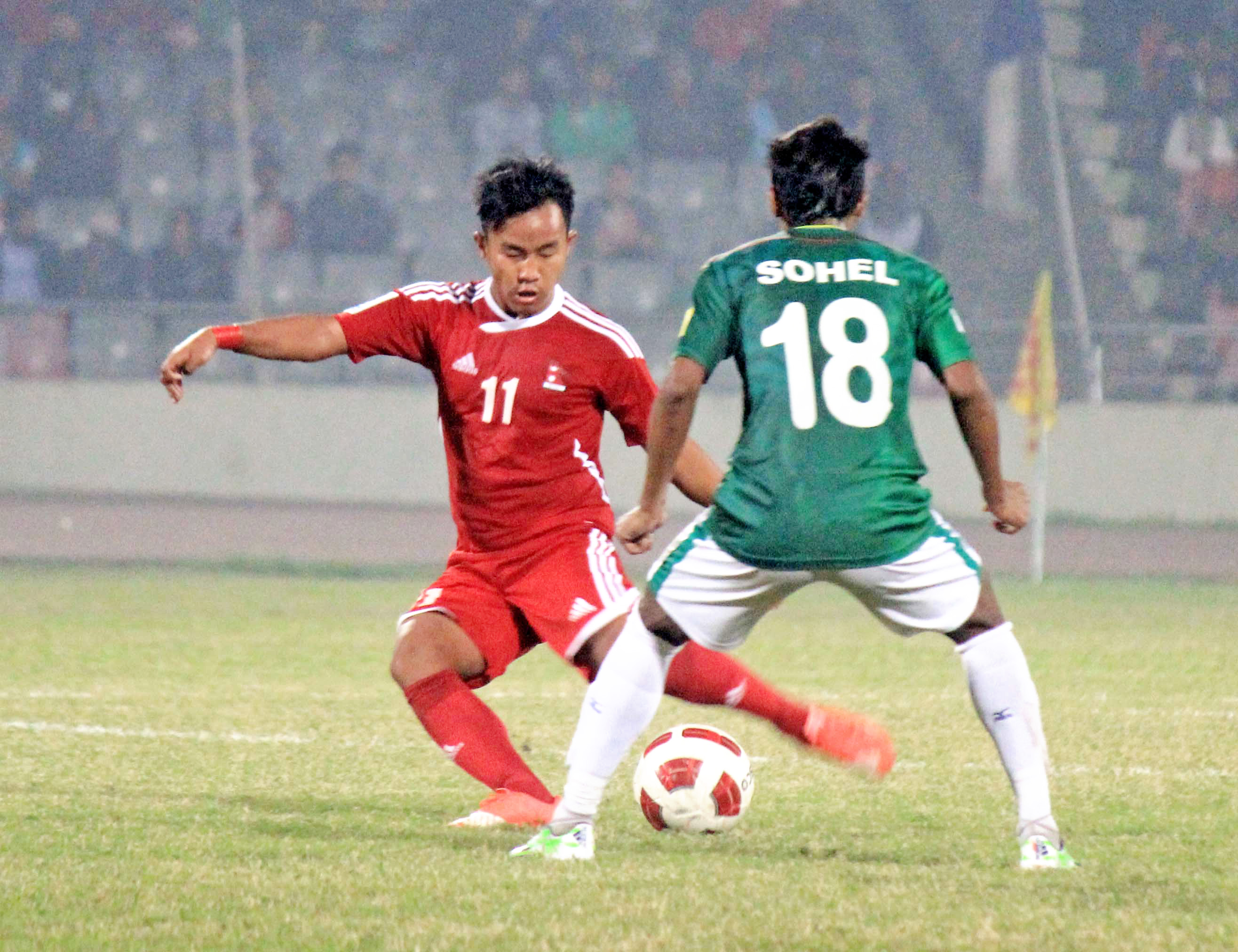 FILE: Nepali player tries to dribble past a Bangladeshi player during their international friendly match at the Bangabandhu Stadium on Thursday, December 17, 2015. Photo: ANFA