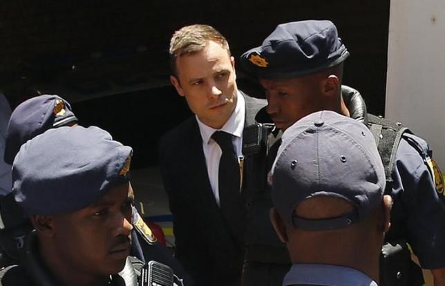 South African Olympic and Paralympic sprinter Oscar Pistorius (C) is escorted to a police van after his sentencing at the North Gauteng High Court in Pretoria October 21, 2014.  REUTERS/Siphiwe Sibeko/Files
