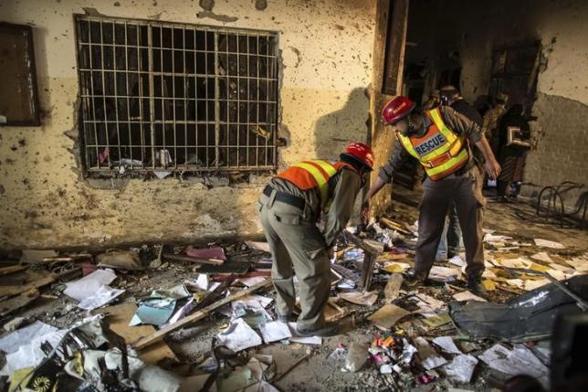 Rescue team members go through debris inside the Army Public School, which was attacked by Taliban gunmen, in Peshawar, December 17, 2014. REUTERS/Zohra Bensemra/files