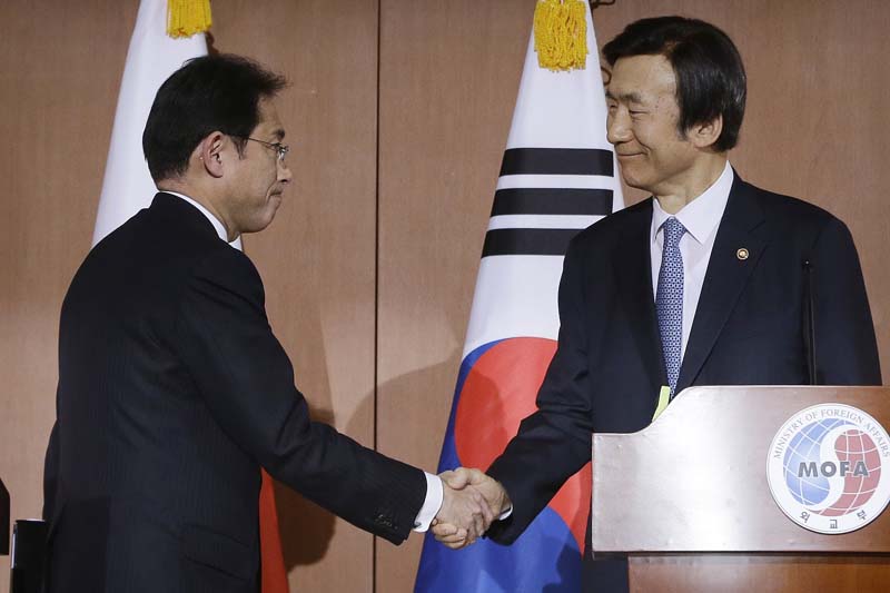 South Korean Foreign Minister Yun Byung-se (right) shakes hands with his Japanese counterpart Fumio Kishida after their joint press conference at Foreign Ministry in Seoul, South Korea, on Monday, December 28, 2015. Photo: AP