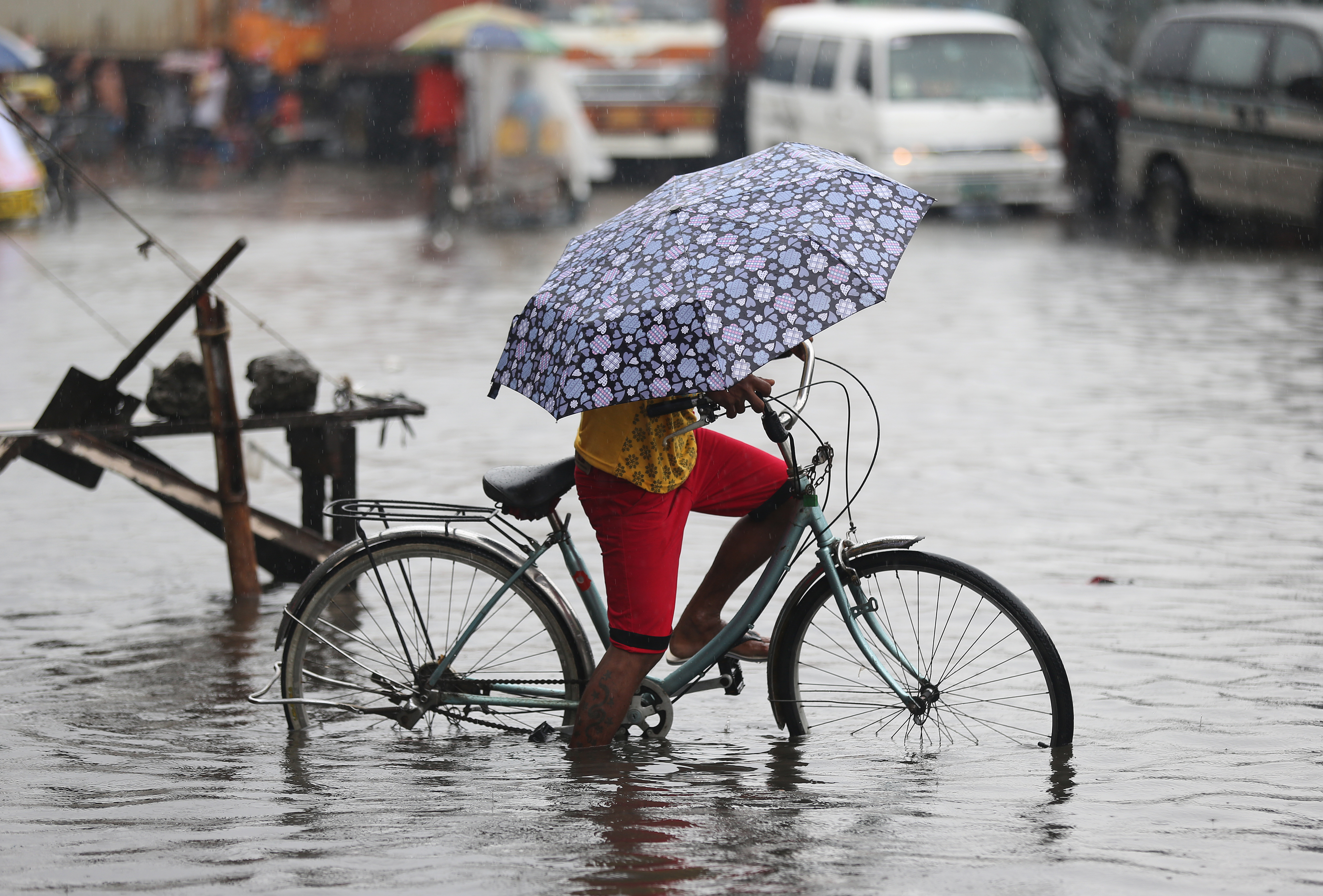 A Filipino tries to bike along a flooded street caused by heavy rains from Typhoon Melor in suburban Navotas, north of Manila, Philippines on Wednesday, Dec. 16, 2015. Photo: Reuters