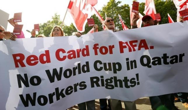 Members of the Swiss UNIA workers union display red cards and shout slogans during a protest in front of the headquarters of soccer's international governing body FIFA in Zurich October 3, 2013. REUTERS/Arnd Wiegmann