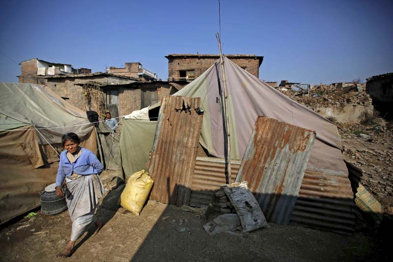 A woman walks along the temporary shelter built near the houses damaged during an earthquake earlier this year, in Bhaktapur, on December 28, 2015. Photo: Reuters