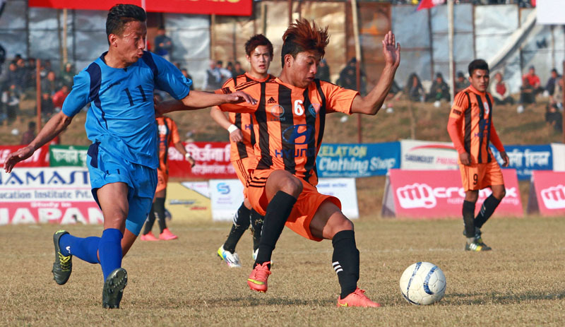 MMC's Amit Tamang (right) and Gorkha Brigade team's Bikram Bompong Rai vie for the ball during their 14th Aaha-Rara Gold Cup match at the Pokhara Stadium on Sunday. Photo: THT
