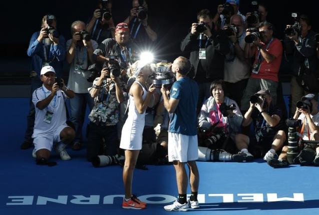 Russia's Elena Vesnina and Brazil's Bruno Soares kiss the mixed doubles trophy after winning their mixed doubles final match at the Australian Open tennis tournament at Melbourne Park, Australia, January 31, 2016. REUTERS/Tyrone Siu