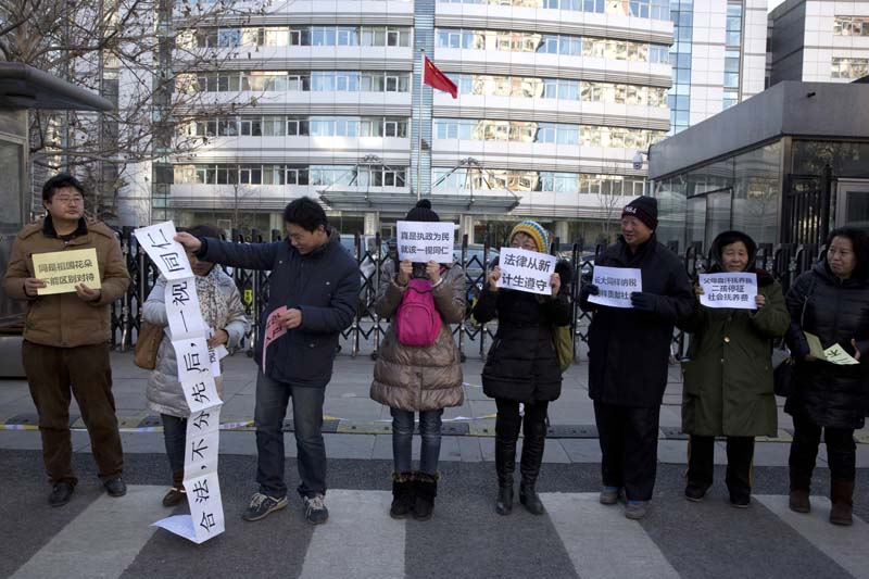 Chinese parents who have children born outside the countryu2019s one-child policy protesting outside the family planning commission in a bid to have their fines canceled in Beijing,on Tuesday, January 5, 2016. Photo: AP