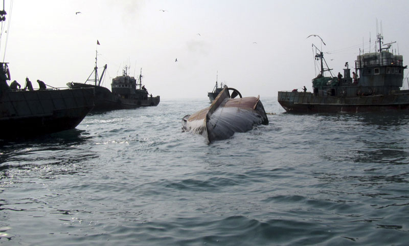 A Chinese fishing boat (centre) is capsized in the water off Gageo Island, South Korea, on Wednesday, January 27, 2016. Photo: South Korean West Sea Fisheries Management Service via AP)