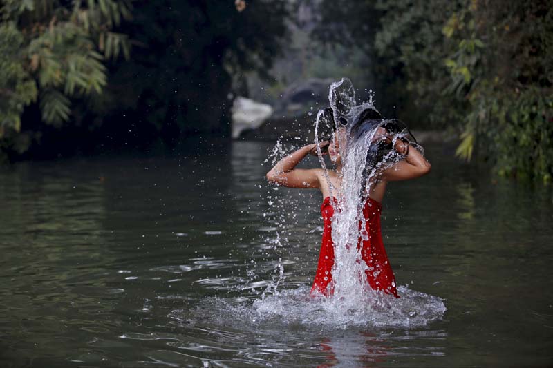 A devotee takes a holy bath in River Saali in Sankhu during the Swasthani Brata Katha festival, a month-long festival where devotees recite one chapter of a Hindu tale daily from the 31-chapter sacred book, in Kathmandu, Nepal, on January 24, 2016. Photo: Reuters