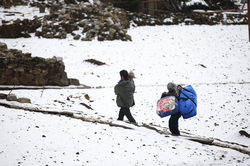 Earthquake-affected locals head to their homes carrying winter relief materials in Helumbu, a village located in Sindhupalchok district on Thursday, January 21, 2016. Photo: Skanda Gautam 