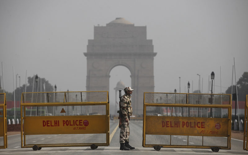 An Indian paramilitary soldier stands guard near a police barricade in front of India Gate, the landmark war memorial on Rajpath, the ceremonial boulevard for Republic Day parade in New Delhi, India, on Thursday, January 21, 2016. Photo: AP