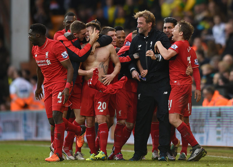 Liverpool's Adam Lallana (centre) celebrates with his teammates and manager Jurgen Klopp (third right) after scoring his side's fifth goal during their English Premier League soccer match against Norwich City at Carrow Road, Norwich, England, on Saturday, January 23, 2016. Photo: AP