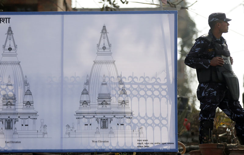 A Nepali policeman stands guard next to a sketch of the Bungamati Temple erected for reconstruction in in Bungmati, Lalitpur, Nepal, on Saturday, January 16, 2016. Photo: AP