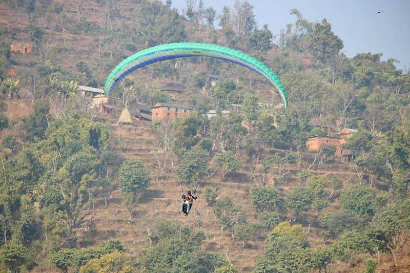 A tourist paragliding from Khantri Danda on the occasion of first Kihu Satikot Gupha Mahotsav organised in Badhar Bhanjyang of Kihu VDC in Tanahun district, on Thursday, January 14, 2016. Photo: Madan Wagle