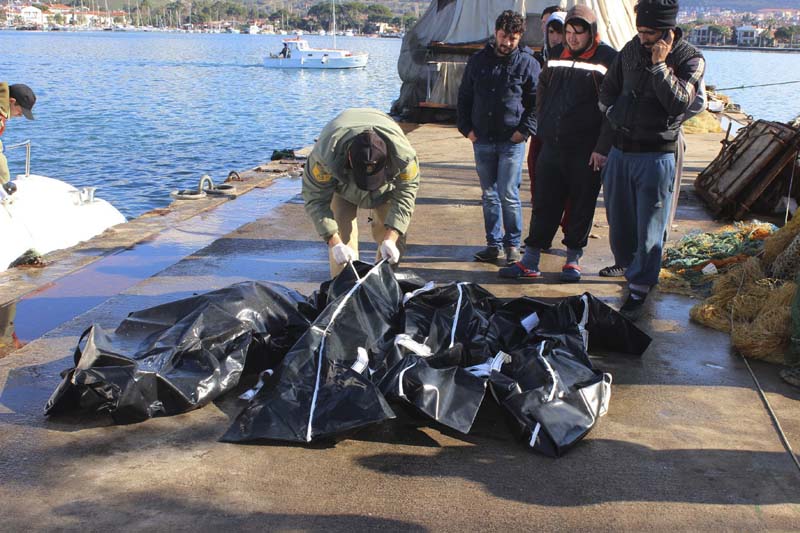 People check bodies of migrants that were drowned as they were trying to reach Greece, at a port near Izmir, Turkey, on Thursday, January 21, 2016. Photo: IHA via AP