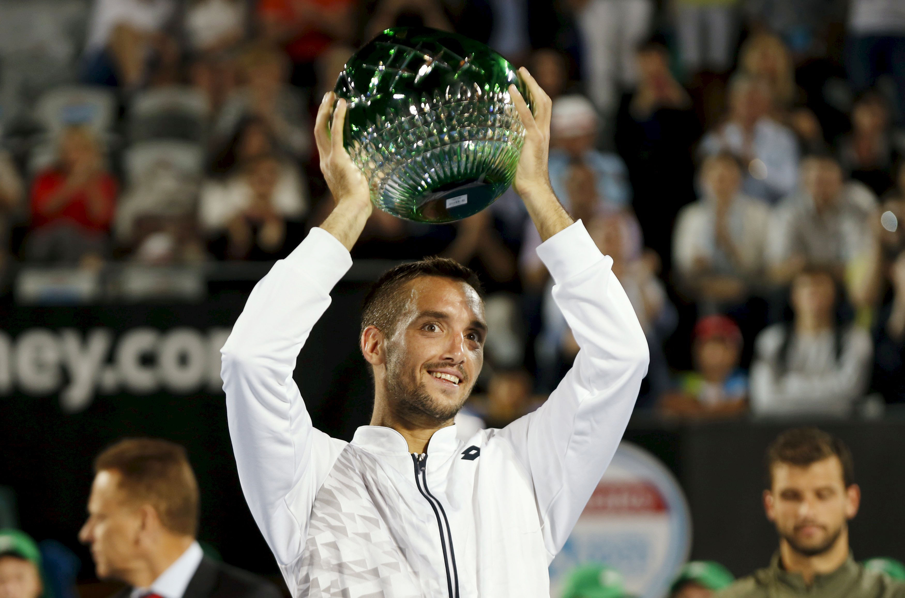 Viktor Troicki of Serbia holds the trophy after winning the Sydney International on Saturday. Photo: Reuters