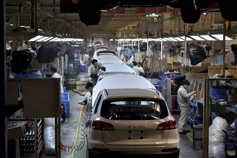 Chinese workers labour on the assembly line of the X5 SUV of Zotye Auto in Hangzhou in east China's Zhejiang province on Monday January 18, 2016. Photo: Chinatopix via AP