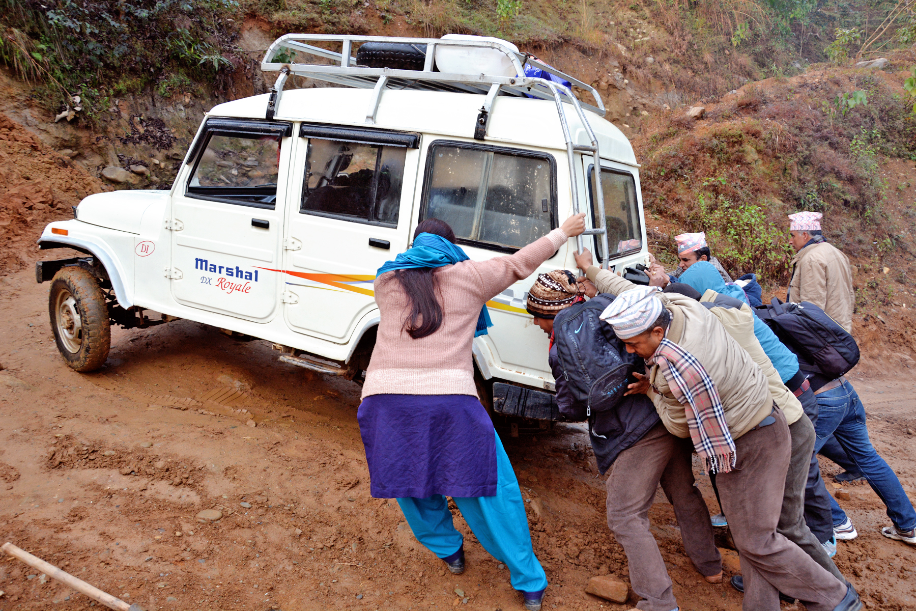 Passengers are compelled to push the vehicle even during the winter days due to lack of timely maintenance of a rural road in Sarkuwa of Baglung district on Sunday, January 24, 2016. Photo: RSS