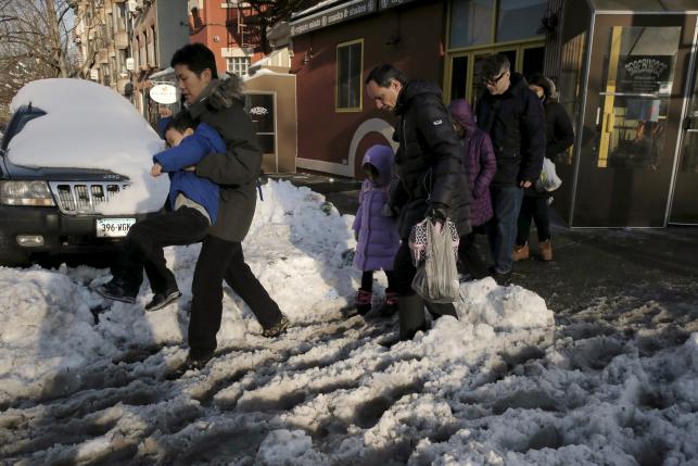 People navigate through the snow and slush during the morning commute in Brooklyn, January 25, 2016. REUTERS/Brendan McDermid
