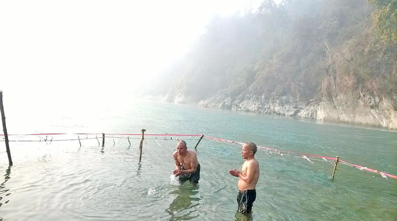 FILE - Men taking a holy dip on the occasion of Maghe Sankranti festival in Devghat, the confluence of Trishuli and kaligandaki Rivers, which border Chitwan, Nawalparasi and Tanahun districts, on Friday, January 15, 2016. Photo : Tilak Ram Rimal